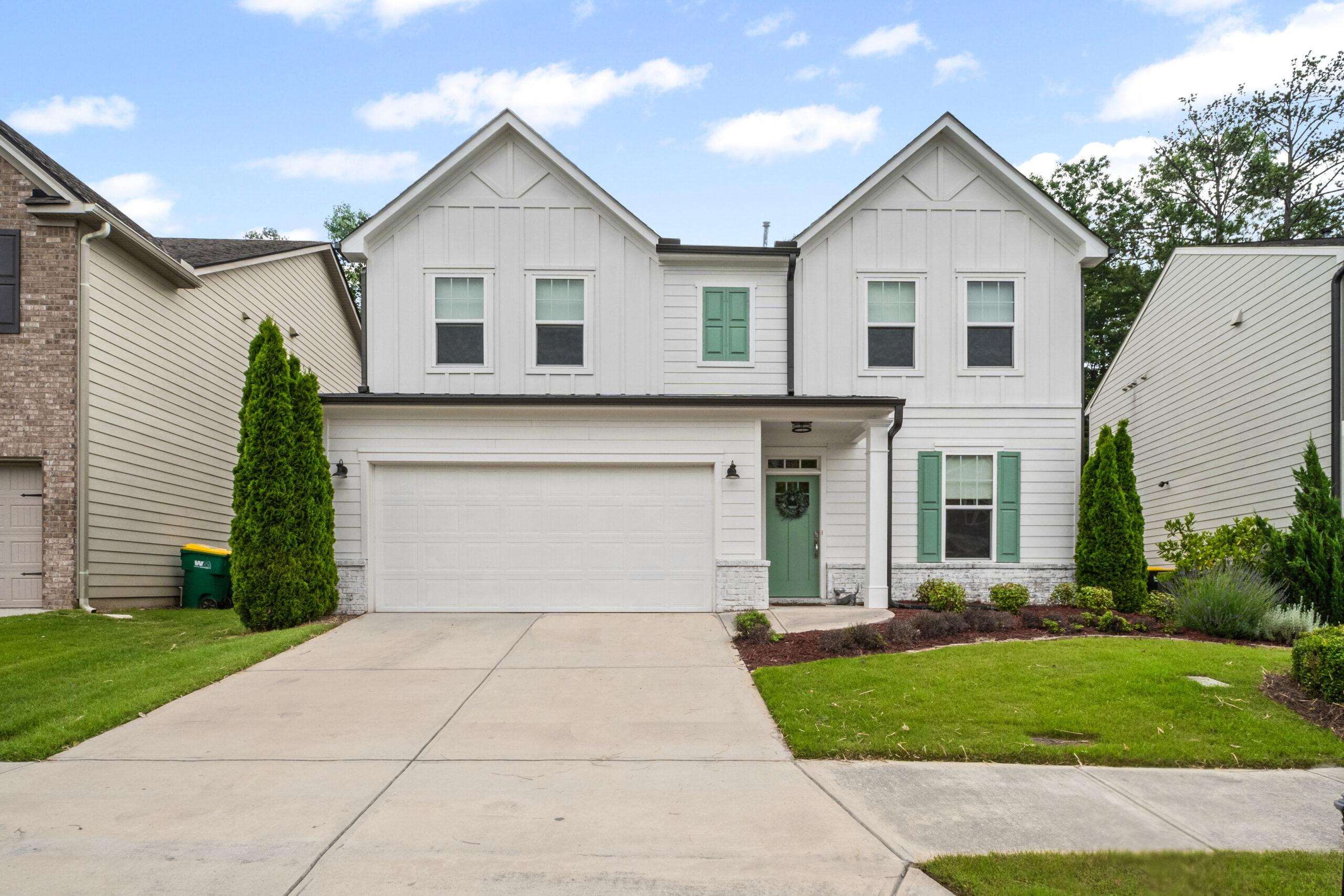 Two-story traditional home in Riverside community, Woodstock GA with landscaped yard and attached garage